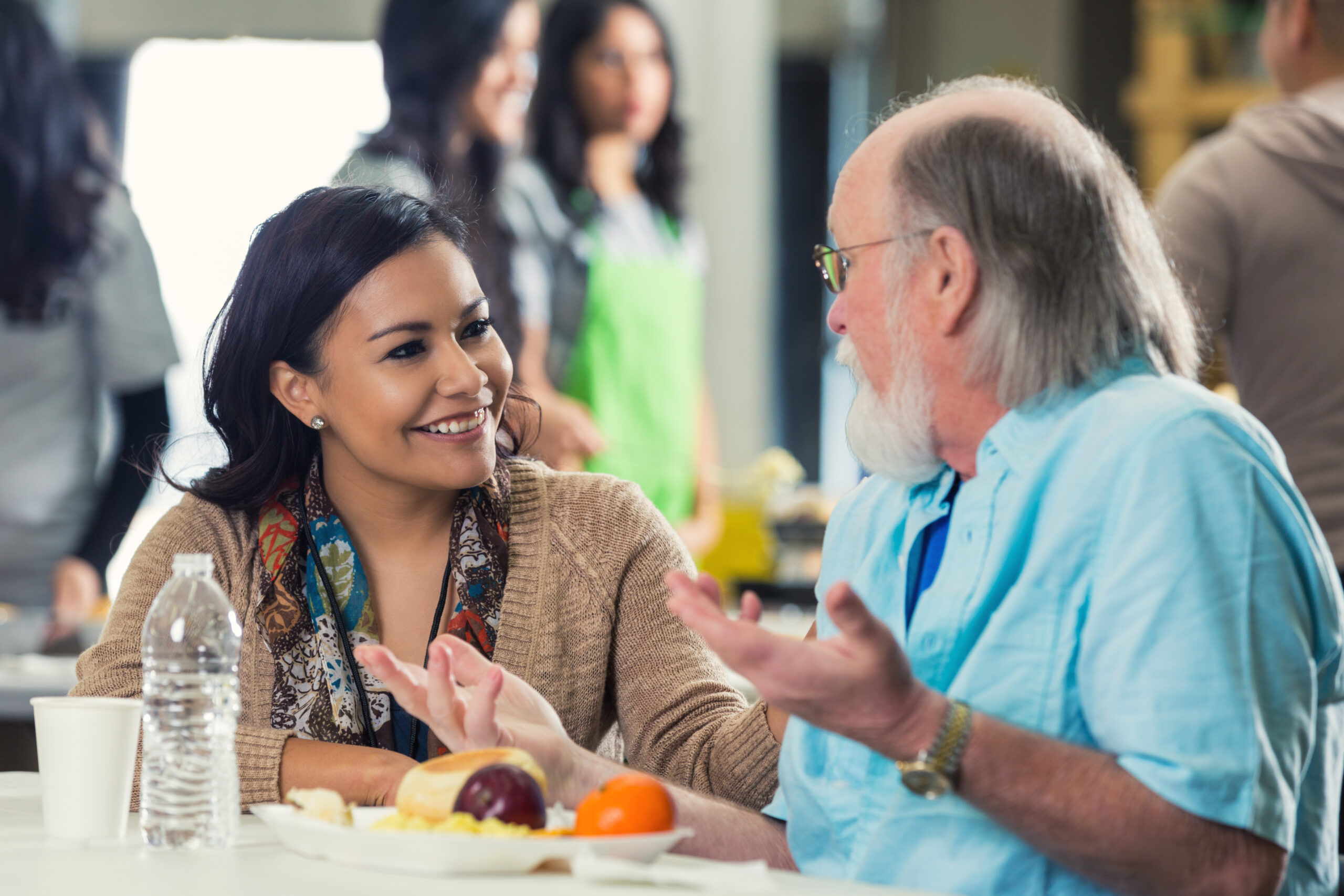 A man and a woman sitting at a table smiling and talking